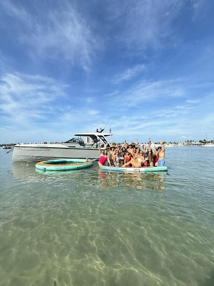 A group of people on a boat and two inflatable rafts in the water with a large yacht in the background. 2