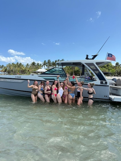 A group of people on a boat with a clear sky and palm trees in the background. 1