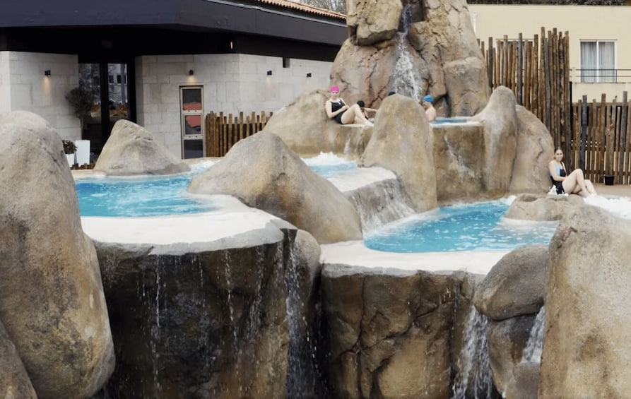 A hot spring area with large rocks and water features. 1
