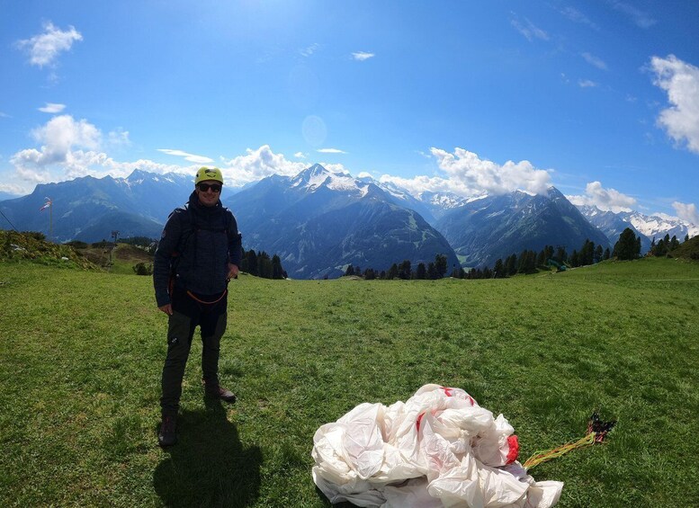 A person standing on a grassy field with a mountainous landscape in the background. 4