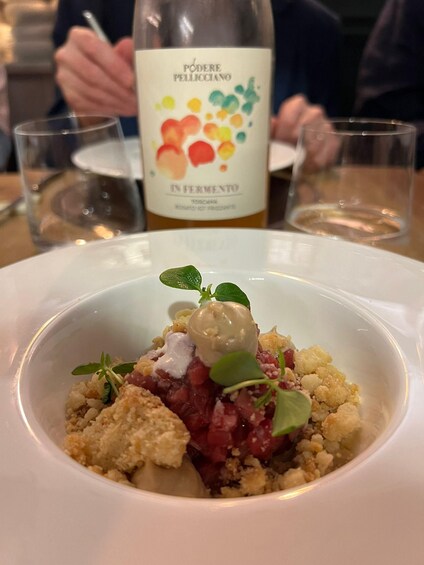 A dish with a bottle of wine in the background. 5