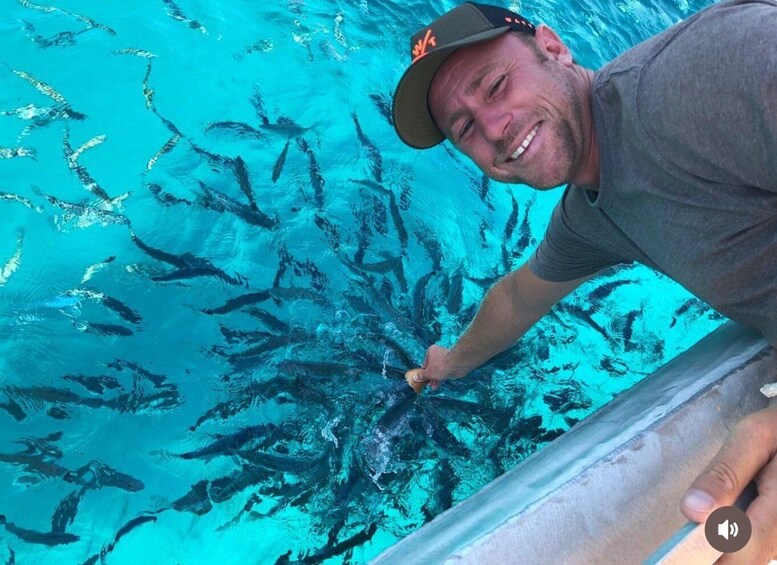 A person in a swimming pool with clear water, holding a small object. 1