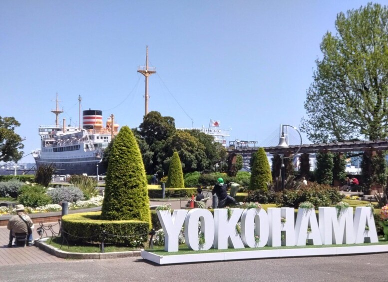 A ship docked at Yokohama port with the Yokohama sign in the foreground. 5