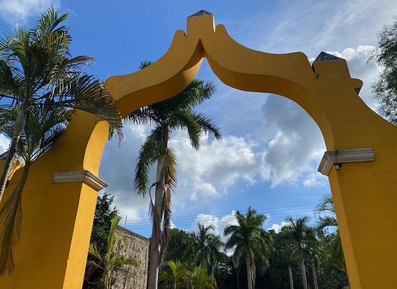 A yellow archway with palm trees in the background. 1