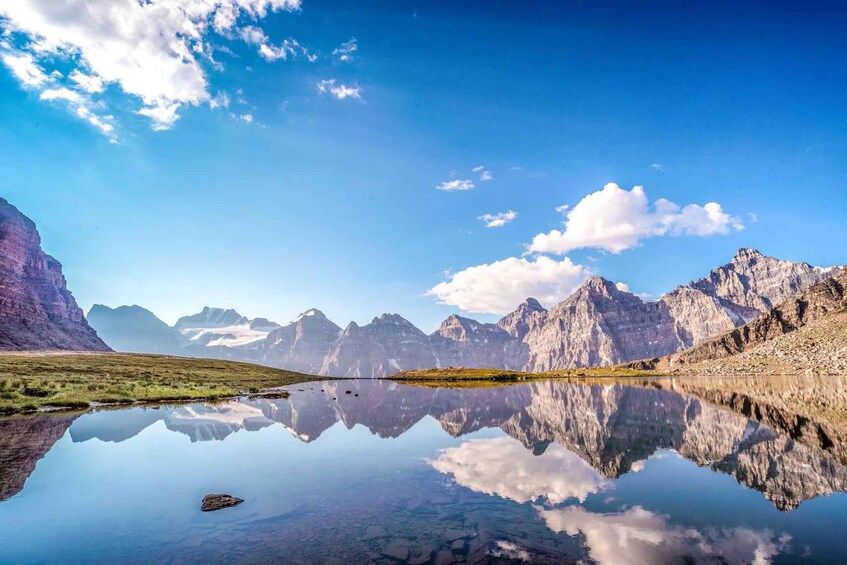 A mountain landscape with a clear lake reflecting the sky and mountains. 5