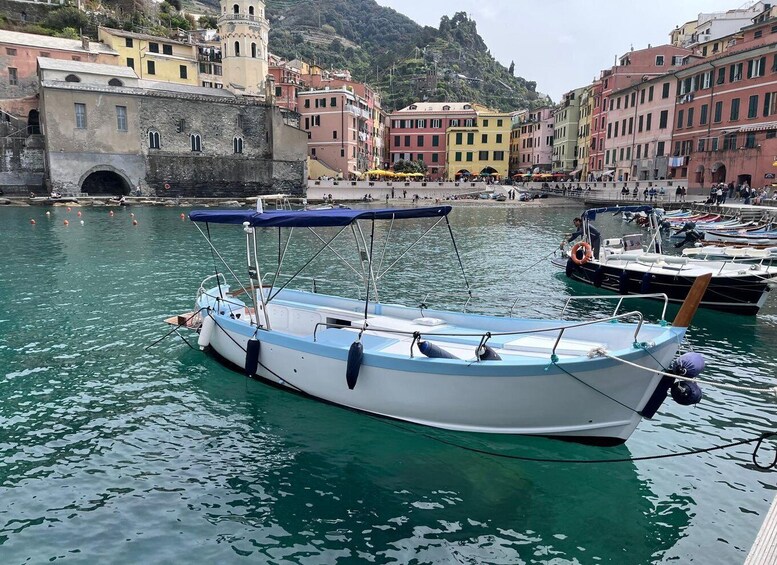 A boat docked at a harbor with colorful buildings in the background. 1