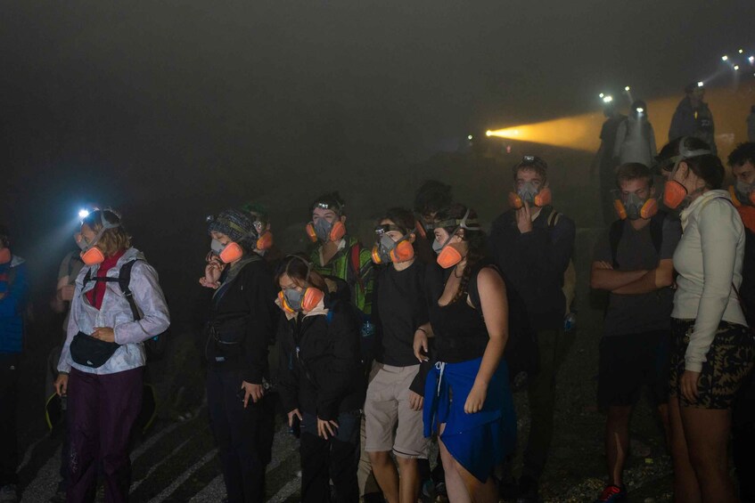 A group of people wearing safety gear, possibly for a nighttime event or activity. 2