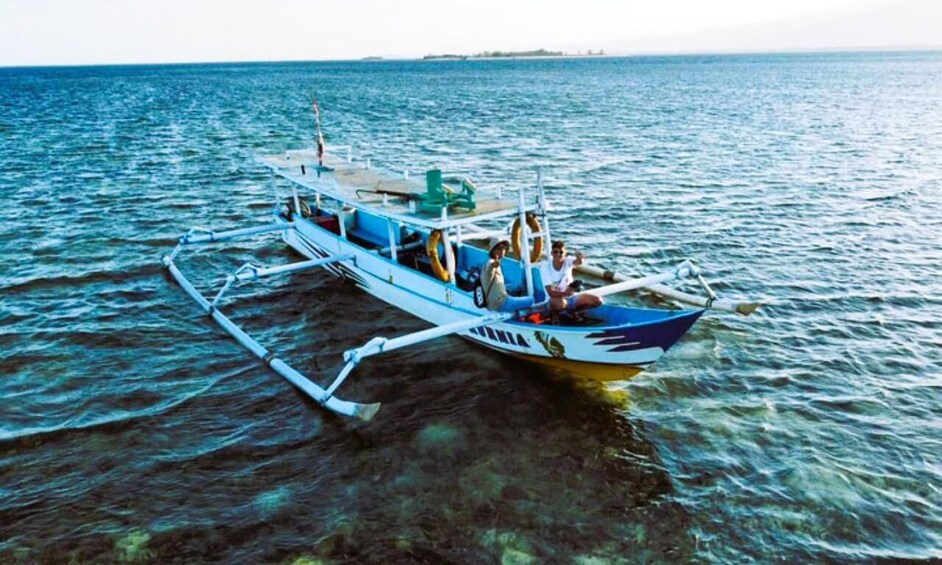 A boat with outriggers on a calm sea. 5