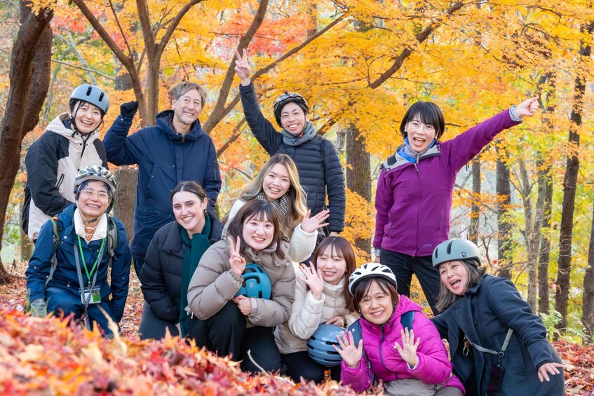 A group of people in a forest with autumn foliage. 4