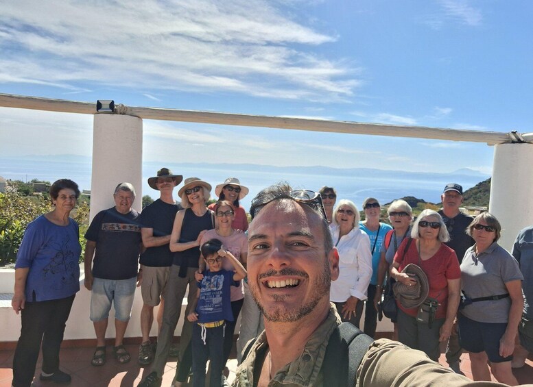 A group of people standing outdoors with a clear sky and distant mountains in the background. 2