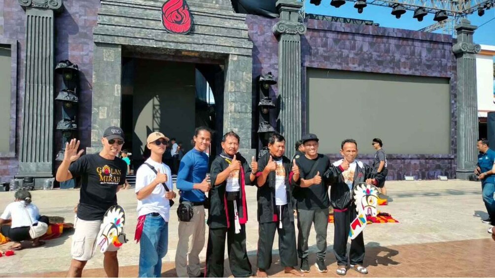 A group of people standing in front of a building with a large red logo. 3