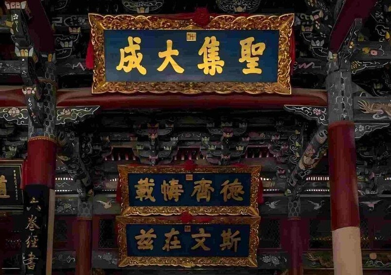 A traditional Chinese architectural structure with ornate decorations and inscriptions. 2