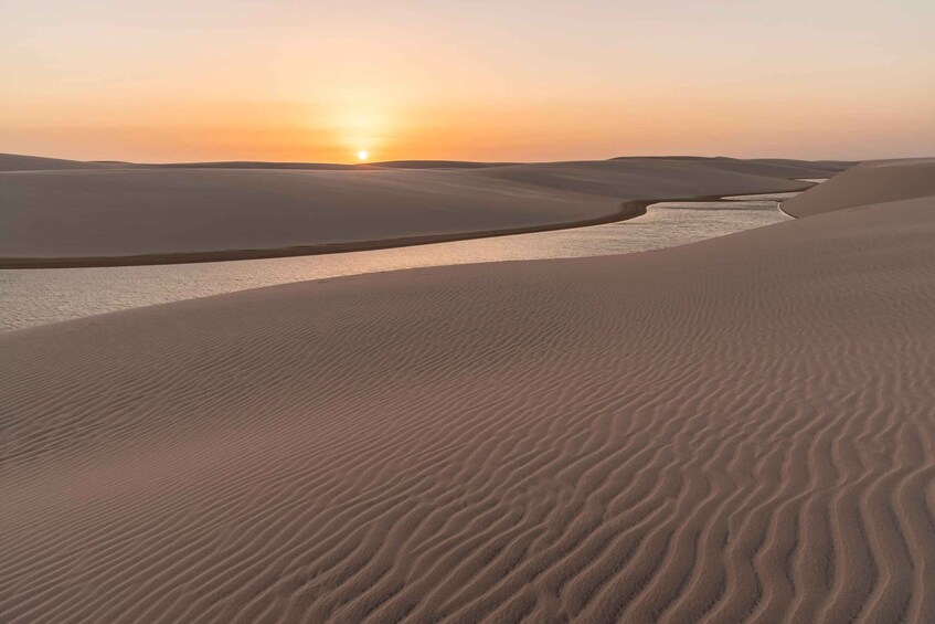 A desert landscape with sand dunes and a river. 2