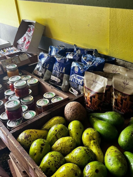 A display of food items including bags of chips, jars of preserves, and green fruits. 4
