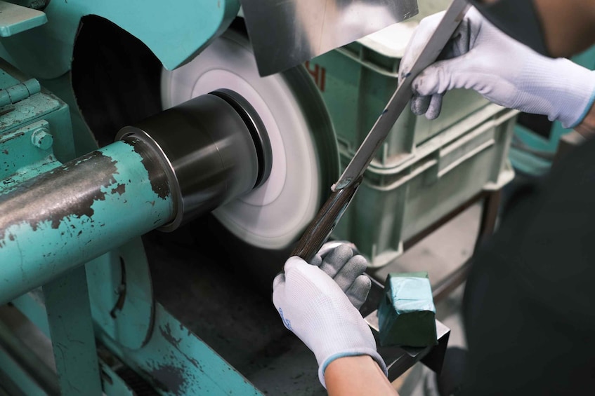 A person wearing gloves working on a machine with a large cylindrical component. 4