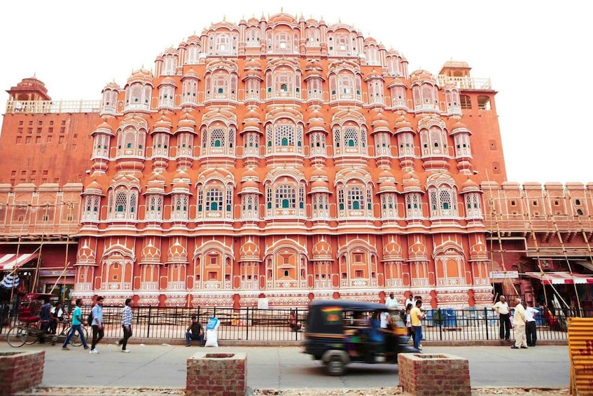 A large, ornate building with intricate architectural details and a busy street in front. 5