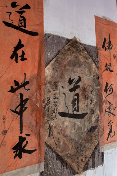 A piece of paper with Chinese calligraphy and a partially visible orange banner. 5