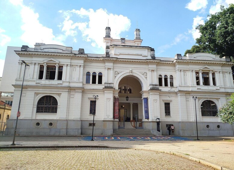 A classical building with a central archway, columns, and decorative moldings. 3