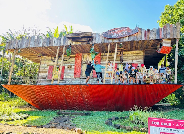 A wooden structure with a sign that reads 'Wailua Caves' and a red boat-shaped platform in front. 2