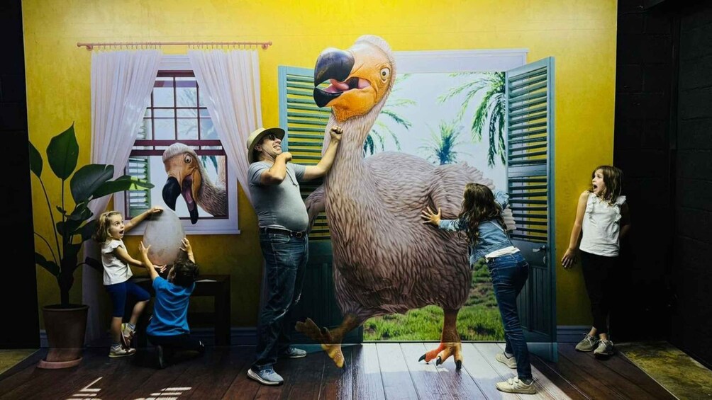 A large toucan sculpture in a room with yellow walls and a window with white curtains. 1
