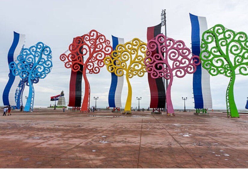 A plaza with colorful tree sculptures and flags. 4