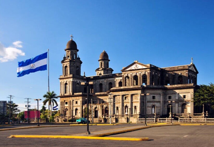 A historic building with two domes and a flag. 1