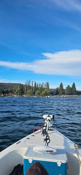 A boat on a body of water with a forested shoreline in the background. 4