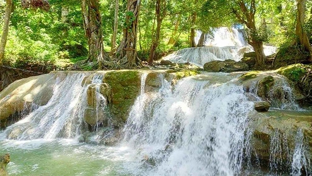 A waterfall cascading over rocks in a forested area. 3