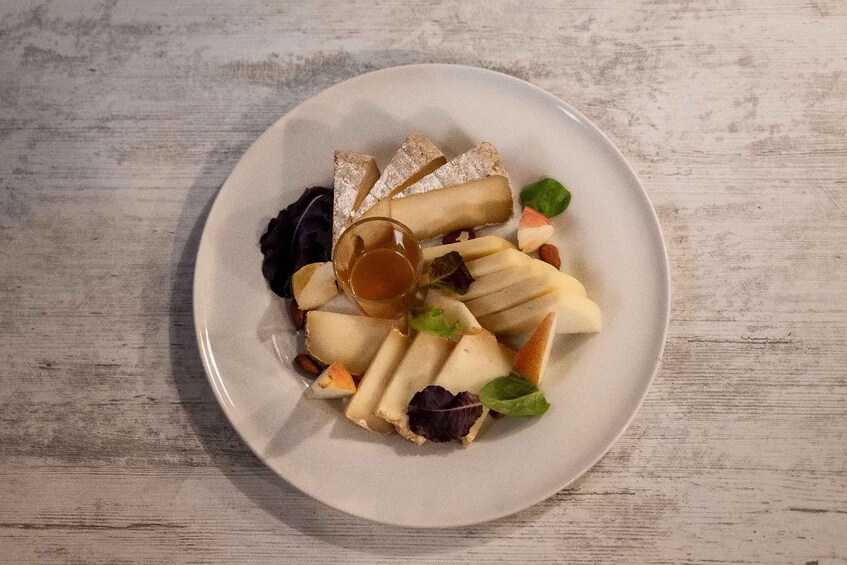 A plate of assorted cheeses and crackers on a wooden table. 3