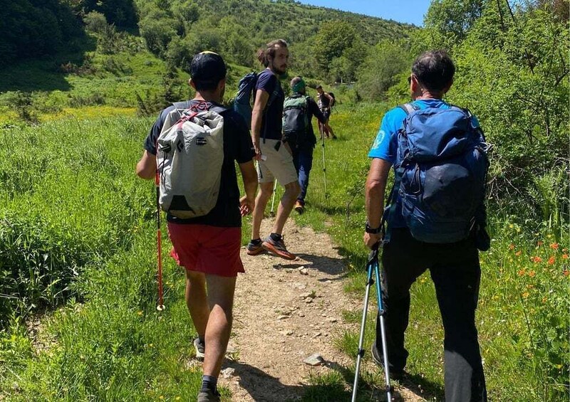 A group of hikers on a dirt trail surrounded by greenery. 5