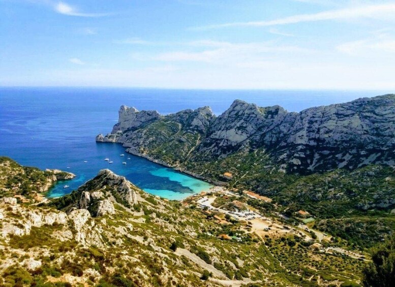 A coastal landscape with rugged mountains, clear blue waters, and a small settlement. 3