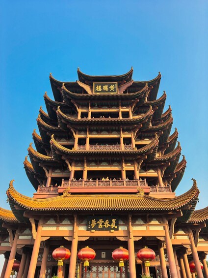 A traditional multi-tiered pagoda with ornate roof tiles and red lanterns. 4