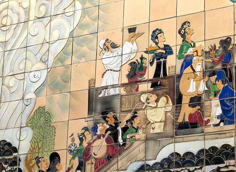 A tiled mural with figures in traditional attire, some playing musical instruments, and others engaged in conversation. 5