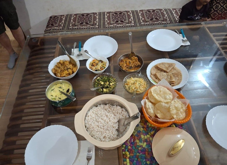 A table with various dishes including rice, flatbreads, and curries. 1