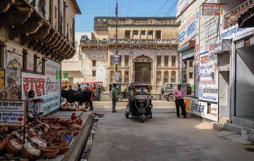 A street scene with traditional architecture, a cow, and various shops. 3