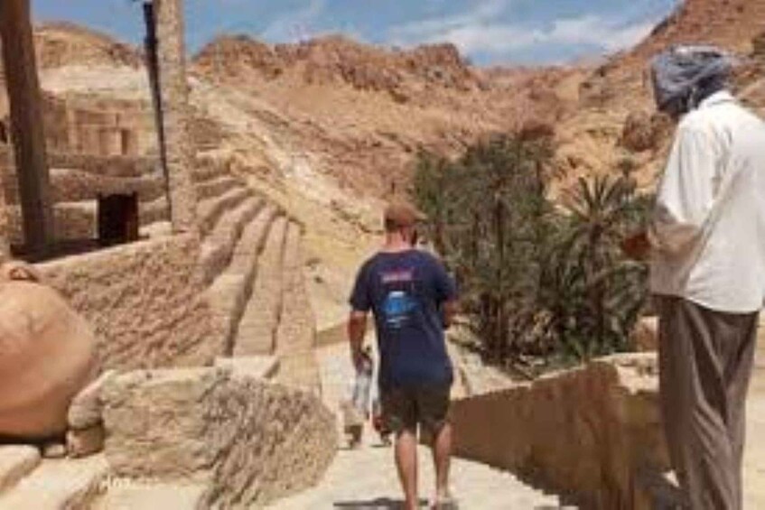 A person walking on ancient stone steps in a desert landscape. 5
