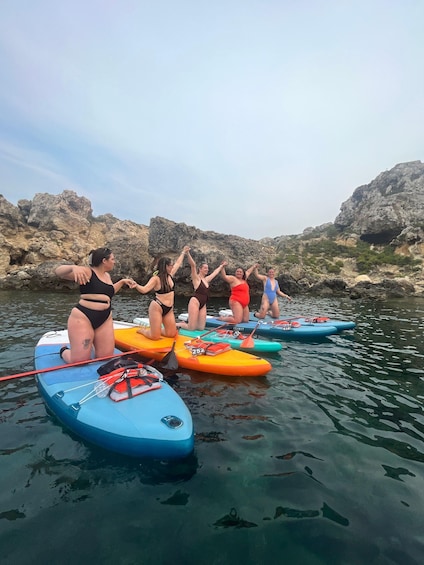 People on paddleboards in a rocky water body. 5
