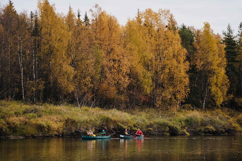 Two people canoeing on a river surrounded by autumn-colored trees. 2