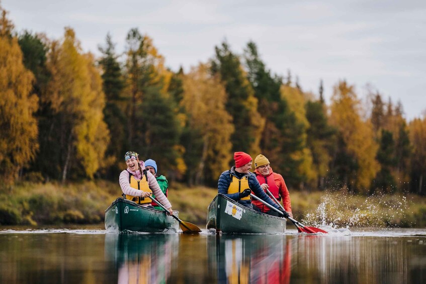 Four people in canoes on a calm river, surrounded by autumn-colored trees. 3