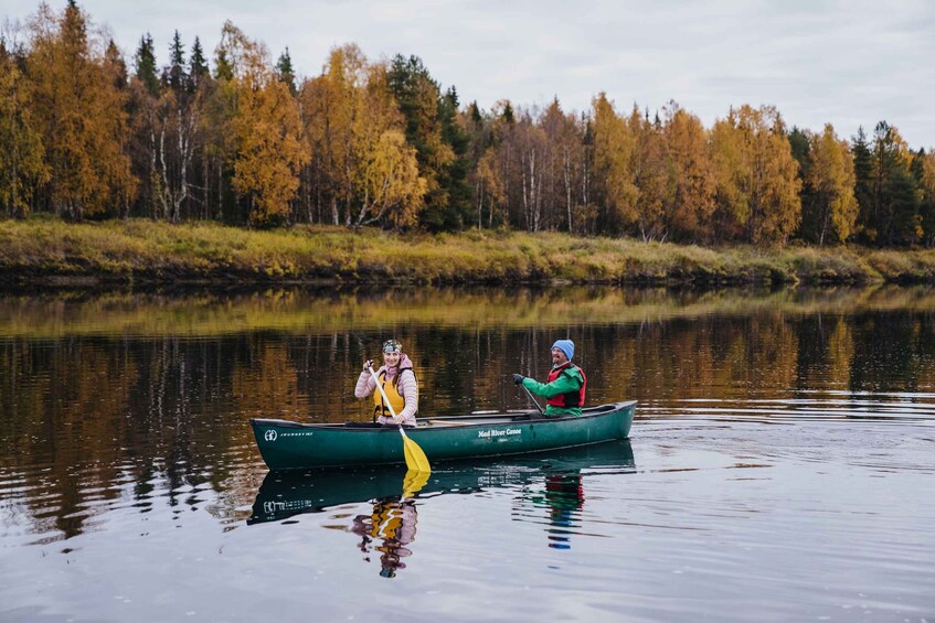 Two people canoeing on a calm river surrounded by autumn trees. 4