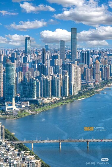 A cityscape with high-rise buildings, a river, and a bridge. 1