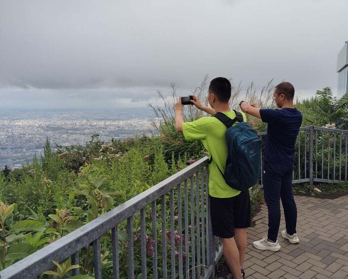 Two people taking a photo of a cityscape from a high vantage point. 5