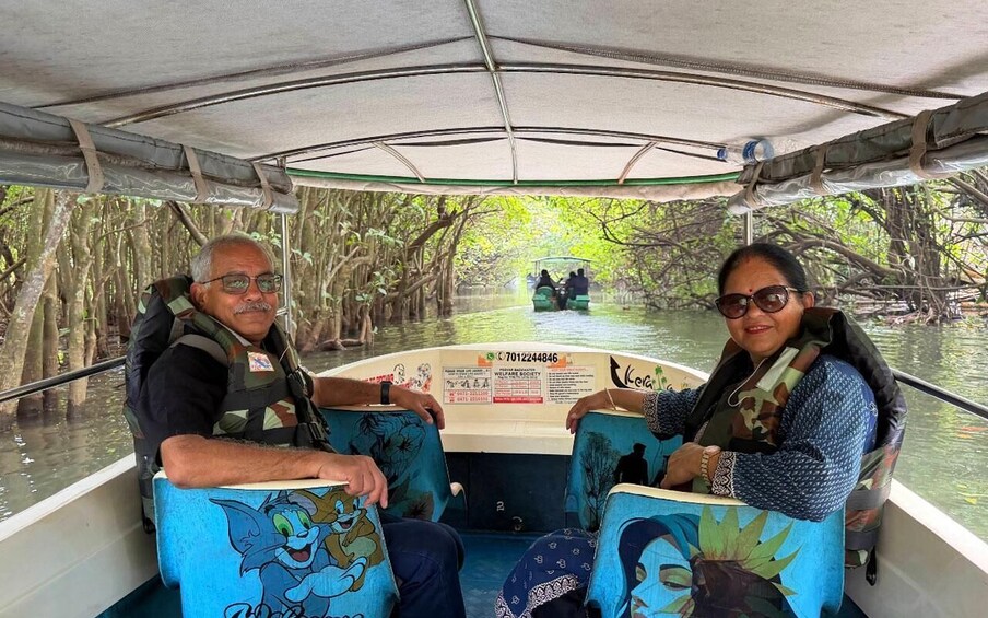 A boat with passengers, surrounded by mangrove trees. 3