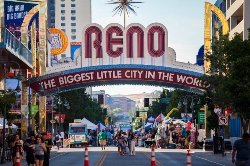 A street with a large sign reading 'RENO THE BIGGEST LITTLE CITY IN THE WORLD' and a star above it. 1