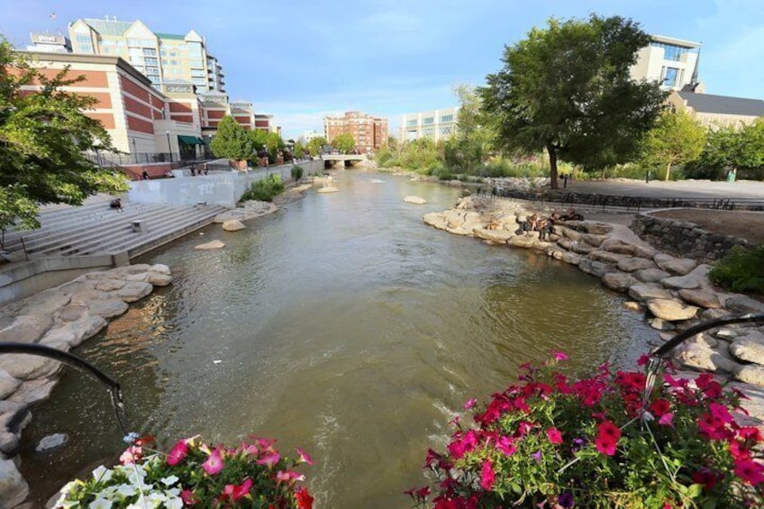 A river with steps leading down to it, surrounded by buildings and trees. 3