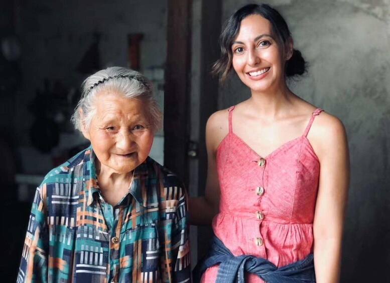 An elderly person in a plaid shirt and a younger person in a pink dress. 3