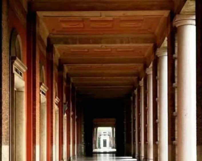 A corridor with columns and a wooden ceiling. 3
