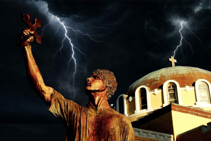 A statue of a man with outstretched arms, lightning in the background, and a building with a dome. 1