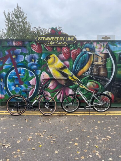 A mural with a bicycle and a sign that reads 'STRAWBERRY LINE Cafe+Cycles'. 1