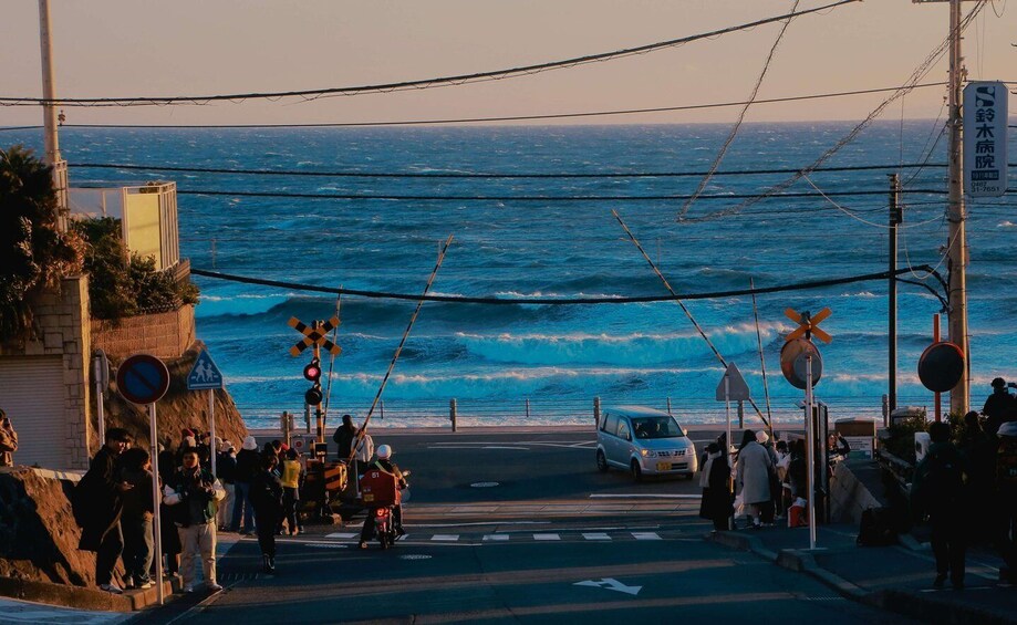 A coastal road with a view of the ocean, traffic signs, and a white car. 2